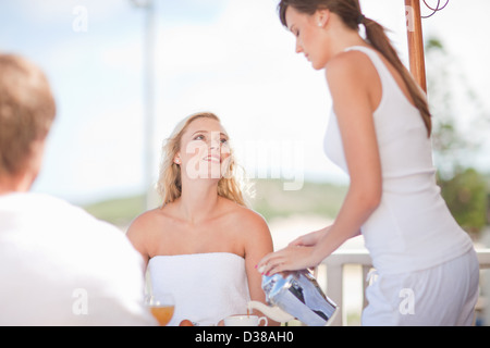 La cameriera che serve caffè donna a tavola Foto Stock