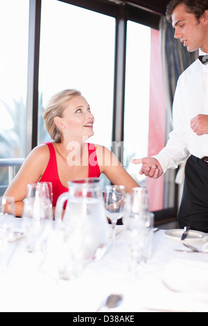 Donna che parla al cameriere al ristorante Foto Stock