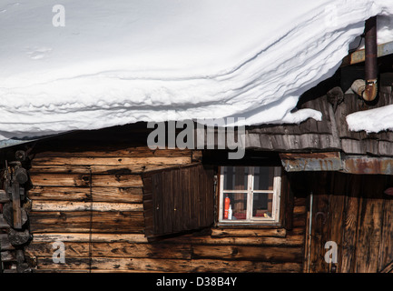 Dettaglio di chalet in legno coperto da neve spesso strato, Obersaxen, Grigioni, Svizzera Foto Stock