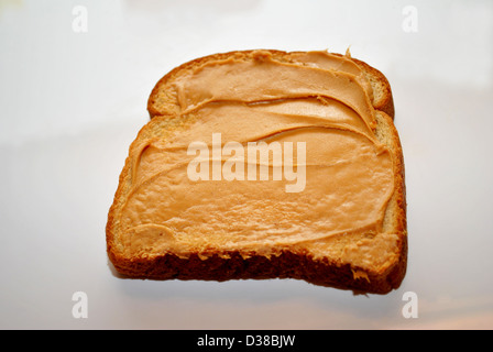 Peanutbutter spalmato sul pane di grano Foto Stock