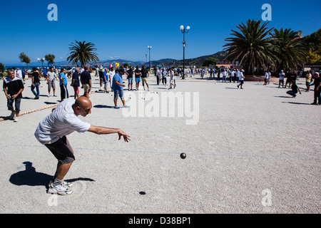 L'uomo giocando a bocce di gettare una boule, Ile-Rousse, Corsica, Francia Foto Stock