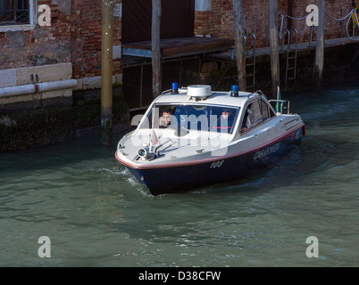 Un veneziano (carabinieri polizia) barca si fa strada lungo uno di Venezia i canali. Foto Stock