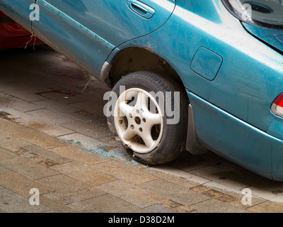 Auto blu con pneumatico forato Foto Stock