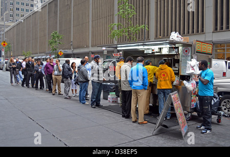 West 53nd Street Manhattan persone in attesa sulla linea per acquistare il pranzo da un Halal, food cart. Foto Stock
