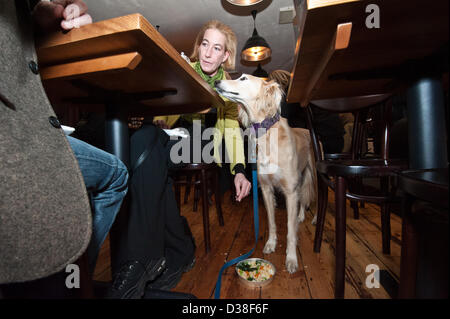 Il meraviglioso miele - un salvato croce Saluki cane ama condividere la cena con il suo nuovo proprietario al mio Doggy cena di San Valentino per i cani e gli amici mentre la raccolta di fondi per i cani la fiducia al carbone Ristorante capannone, Brighton East Sussex, Regno Unito. Il 12 febbraio 2013. Foto di Julia Claxton/Alamy live news. Foto Stock