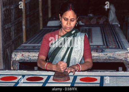 Donna tessile lavoratore stampa con un blocco di legno su cotone. Manikganj, Bangladesh Foto Stock