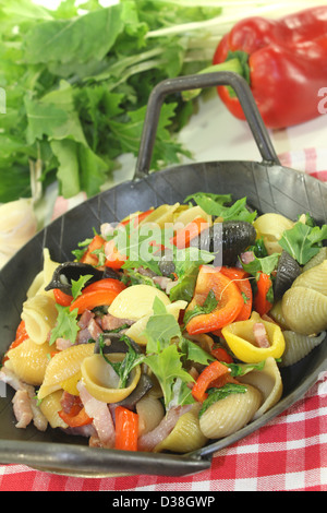 Pasta colorata padella con peperone, cime di rapa, strisce di prosciutto, pomodori e aglio Foto Stock