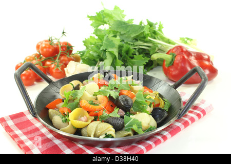 Pasta fresca la padella con peperone, cime di rapa, strisce di prosciutto, pomodori e aglio Foto Stock