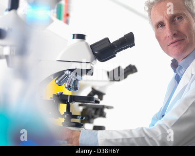 Scienziato usando microscopio in laboratorio Foto Stock