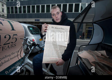 Londra, Regno Unito. Il 13 febbraio 2013. Un giornale fornitore su un rickshaw contiene una copia del primo Financial Times edizione pubblicata il 13 febbraio 1888. Il Financial Times celebra il suo centoventicinquesimo anniversario con una edizione speciale. Amer Ghazzal / Alamy Live News Foto Stock