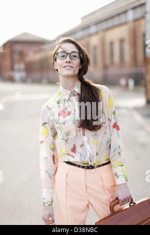 Donna in piedi su una strada di città Foto Stock