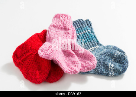 Mano a maglia baby calze su sfondo bianco Foto Stock