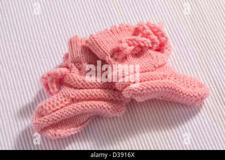 Coppia di auto in maglia rosa calze bambino su sfondo bianco Foto Stock