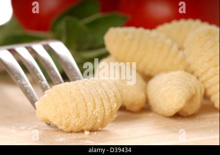 Deliziosi fatti a mano Gnocchi utilizzando una forcella con i pomodori e le erbe Foto Stock