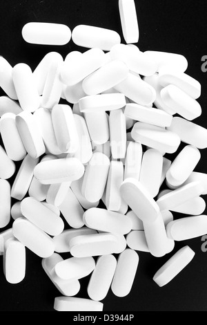 Molte pillole bianco isolato su nero. Foto in bianco e nero. Foto Stock