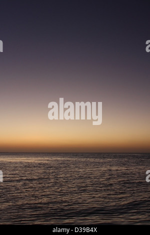 Tramonto su un mare calmo Foto Stock