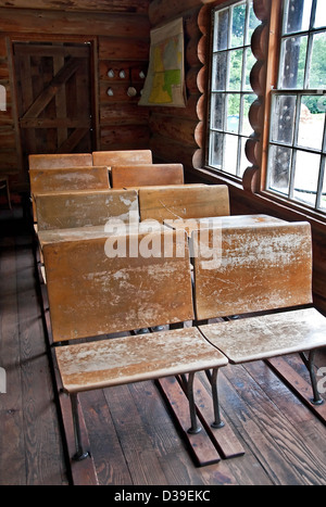 Questa è una scuola di vintage in una capanna di legno con molta luce naturale filtraggio nel attraverso le finestre e colpendo le righe di legno Foto Stock
