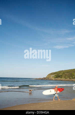 A piedi con tavole da surf su una spiaggia Foto Stock