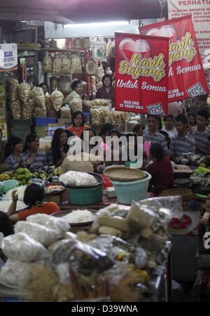 Solo, Giava centrale, Indonesia. 14 febbraio 2013. Gli studenti hanno celebrato il giorno di San Valentino con fiori e cioccolatini distribuiti agli operatori economici il 14 febbraio 2013 a Pasar Gede, Solo, Giava centrale, Indonesia. Gli studenti anche cantato una canzone mentre si cammina intorno al mercato per intrattenere i mercanti. (Immagine di credito: credito: Sijori Immagini/ZUMAPRESS.com/Alamy Live News) Foto Stock