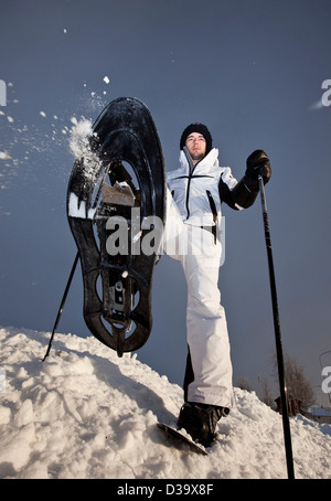 Uomo con le racchette da neve a piedi attraverso la neve, la Lapponia Foto Stock