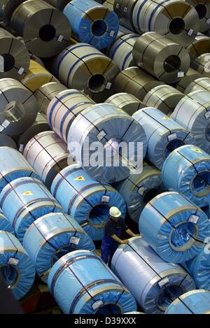 (Dpa) - Un lavoratore sorge tra le bobine di acciaio che sono pronti per la spedizione alla ThyssenKrupp AG acciaierie Duisburg-Bruckhausen, Germania occidentale, 1 settembre 2003. Lo stabilimento produce parti di acciaio e bobine che vengono utilizzati per la costruzione di vetture che le macchine di lavaggio e delle turbine a vento. 13.000 Foto Stock