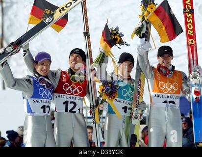 (Dpa) - XIX edizione dei Giochi Olimpici Invernali: il tedesco K120 ski-jumping team, (l-r) Martin Schmitt, Sven Hannawald, Stephan Hocke e Michael Uhrmann, celebrare la loro vittoria sventolando bandiere, fiori e loro ski durante la cerimonia dei fiori a Utah Olympic Park, 18.2.2002, alla Olimpiadi invernali di Salt Lake City. Foto Stock