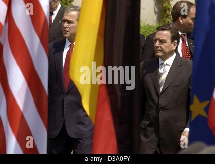 (Dpa) - Il presidente statunitense George W. Bush (L) e il cancelliere tedesco Gerhard Schroeder sostare dietro la loro nazione bandiere su una conferenza stampa a Berlino, 23 Maggio 2002.hanno annunciato che gli Stati Uniti e la Germania hanno convenuto in tutte le importanti questioni politiche che comprendeva la necessità di continuare la guerra contro Foto Stock