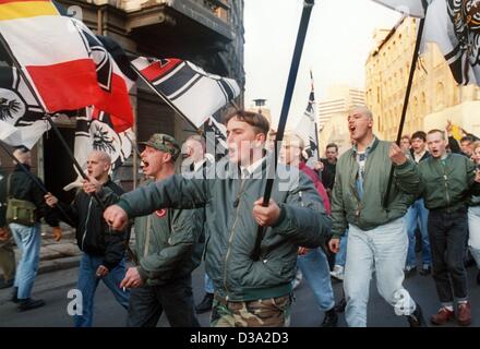 (Dpa file) - estremista di destra manifestanti hold up flag nazista (Reichskriegsflagge) e gridare slogan durante una manifestazione per celebrare il secondo anniversario della riunificazione della Germania a Halle, Germania, 10 novembre 1991. Foto Stock