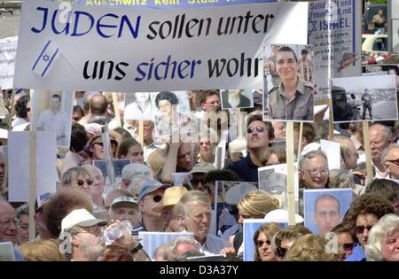 (Dpa) - manifestanti tenere banner che leggere "gli ebrei devono vivere savely con noi" e le foto di parenti che sono morti in attentati, durante una manifestazione contro il terrore e l'antisemitismo a Monaco di Baviera, 12 luglio 2002. Foto Stock