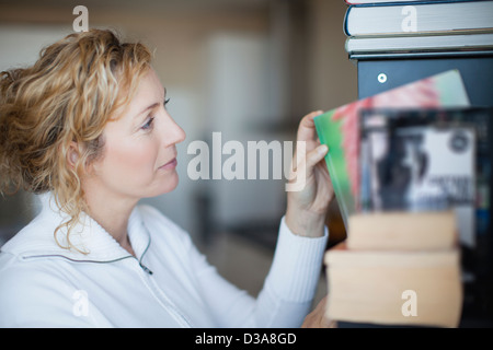 Donna organizzando scaffale Foto Stock