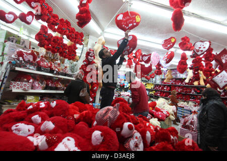Febbraio 14, 2013 - Gaza City, nella Striscia di Gaza, Territori palestinesi - un uomo palestinese decora il suo negozio con doni il giorno di San Valentino in Cisgiordania città di Ramallah, il 14 febbraio 2013. Il giorno di San Valentino è sempre più popolare della regione come le persone che hanno preso l'abitudine di dare fiori, carte, cioccolatini e regali per innamorati per celebrare l'occasione (credito Immagine: © Issam Rimawi APA/images/ZUMAPRESS.com) Foto Stock