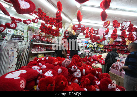 Febbraio 14, 2013 - Gaza City, nella Striscia di Gaza, Territori palestinesi - un uomo palestinese decora il suo negozio con doni il giorno di San Valentino in Cisgiordania città di Ramallah, il 14 febbraio 2013. Il giorno di San Valentino è sempre più popolare della regione come le persone che hanno preso l'abitudine di dare fiori, carte, cioccolatini e regali per innamorati per celebrare l'occasione (credito Immagine: © Issam Rimawi APA/images/ZUMAPRESS.com) Foto Stock