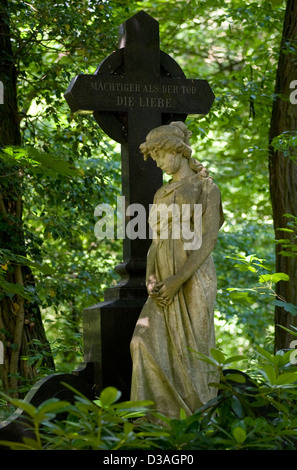 Stahnsdorf, la Germania, la statua di una donna con una croce sul Suedwestkirchhof Stahnsdorf Foto Stock