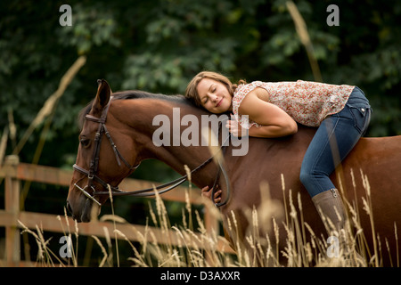 La donna caucasica posa su cavallo a penna Foto Stock