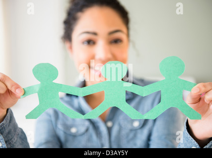 Donna ispanica tenendo le bambole di carta Foto Stock