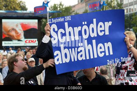 (Dpa) - i sostenitori del candidato cancelliere Edmund Stoiber hold up posters durante Stoiber della campagna elettorale manifestazione di Hannover, Germania, 9 settembre 2002. Il poster in primo piano si legge "voto Schroeder fuori ufficio" accanto a Stoiber della campagna elettorale slogan 'tempo per azioni" (Zeit fuer Taten) Foto Stock