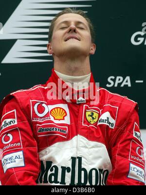 (Dpa) - tedesco di Formula Uno del Campione del Mondo in carica Michael Schumacher ascolta l'inno nazionale tedesco dopo aver vinto il primo posto il belga della F1 Grand Prix sulla pista di Spa Francorchamps, Belgio, 1 settembre 2002. Foto Stock