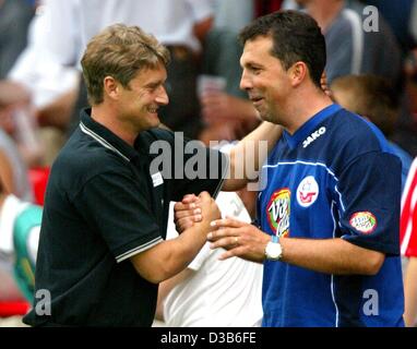 (Dpa) - Rostock's soccer coach Armin Veh (L) abbraccia il suo assistente Juri Schluenz dopo la loro squadra ha vinto la partita FC Hansa Rostock contro FC Energie Cottbus a Cottbus, Germania, 24 agosto 2002. Rostock ha vinto 4:0, rimanendo così secondo in classifica. Foto Stock