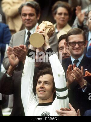 (Dpa file) - Franz Beckenbauer, quindi il team tedesco capitano, felicemente solleva la "Coupe Jules Rimet' dopo aver vinto i Mondiali di Calcio a Monaco di Baviera, 7 luglio 1974. A destra dietro Beckenbauer applaudes Pieter van Vollenhofen. La Germania ha sconfitto i Paesi Bassi 2:1 in finale. Foto Stock