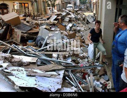 (Dpa) - Una donna che sta facendo il suo modo attraverso la spazzatura dalle case inondate di accatastamento su strada a Pirna, 21 agosto 2002. Dopo l'acqua alta ritirato e lasciato un caos, i residenti sono impegnati per la pulizia. Le peggiori inondazioni in Germania in un secolo ha causato danni catastrofici stimata in bil Foto Stock