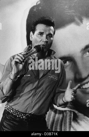 (Dpa file) - Tedesco Rock'n'Roll legend Ted Herold esegue nella parte anteriore di un Elvis Presley poster in Amburgo, 14 agosto 1987. Herold celebrerà il suo sessantesimo compleanno il 9 settembre 2002. Ha iniziato la sua carriera nella sua high school tempo dopo che egli aveva avuto una chitarra per Natale nel 1956. " Il tedesco Elvis Pr Foto Stock