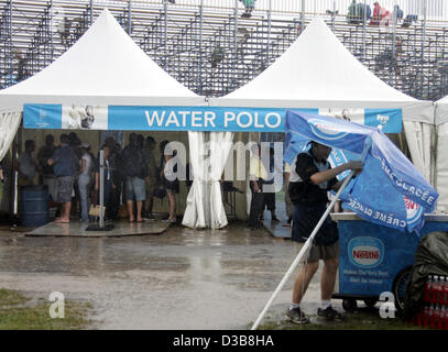 (Dpa) - spettatori cercano rifugio sotto due tabelloni elettronici da una pioggia pesante all'ingresso per la pallanuoto stadium durante il nuoto nel campionato del mondo a Montreal, Canada, Martedì, 19 luglio 2005. Foto Stock