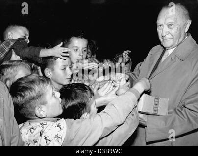 (Dpa file) - West il Cancelliere tedesco Konrad Adenauer distribuisce il cioccolato per i bambini davanti a una campagna elettorale evento in Bubenreuth, Germania Ovest, 11 settembre 1957. Il 81-anno-vecchio è stato in tournée in Germania per quattro settimane in treno prima delle elezioni generali. Adenauer fu il primo Chancello federale Foto Stock