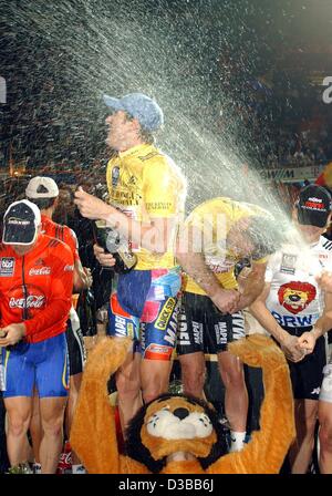 (Dpa) - I vincitori del 39th sei giorni di gara di Monaco di Baviera, ciclista australiano Scott McGrory (C) sinistro e il suo partner belga Matthew Gilmore (C) a destra, entrambi del team Mapei, splash champagne con il secondo posto svizzero Bruno Risi (R) e al terzo posto il tedesco Andreas Beikirch durante la cerimonia di premiazione si terrà a Foto Stock