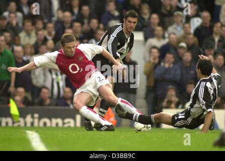 (Dpa) - Arsenale il defender Oleg Luzhny da Ukraina (L) combatte per la palla con il Newcastle giocatori Nikolaos Dabizas dalla Grecia (R) e Aaron Hughes dall Irlanda del Nord (C) durante il match di Premier League Arsenal Londra contro il Newcastle United in Highbury Stadium di Londra, 9 novembre 2002. Foto Stock