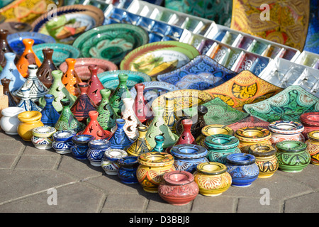 Gli ingredienti di base di una tagine , posacenere, piastre e altri souvenir marocchini sul display nel souk di Marrakech, Marocco. Foto Stock