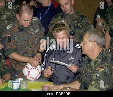 (Dpa) - nazionale tedesco di portiere Oliver KAHN (C) firma autografi per i soldati del tedesco tedesco la SFOR (forza di stabilizzazione) truppe di stanza sul balcanica, in un accampamento militare a Sarajevo, Bosnia ed Erzegovina, 10 ottobre 2002. Il giorno successivo un amichevole partita di calcio Germania versus Bosnia-Herce Foto Stock