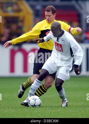 (Dpa) - Dortmund è difensore e capitano della squadra Stefan Reuter (L) combatte per la palla con Bielefeld il percussore di Mamadou Lamine Diabang dal Senegal durante la Bundesliga partita di calcio Borussia Dortmund contro Arminia Bielefeld a Dortmund, Germania, il 19 ottobre 2002. La partita si è conclusa in un 0:0 tie. Foto Stock