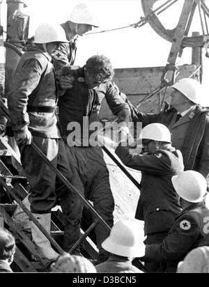 (Dpa file) - Miner Fritz Baer è il secondo uomo di essere salvato dalla miniera di 'Mathilde' in Lengede, Germania Ovest, 7 novembre 1963. 500 minatori testimone diretto le operazioni di salvataggio presso la piattaforma di perforazione derricks. Il 24 ottobre un burst dam si era allagata la miniera e intrappolata 129 minatori; 29 uomini Foto Stock