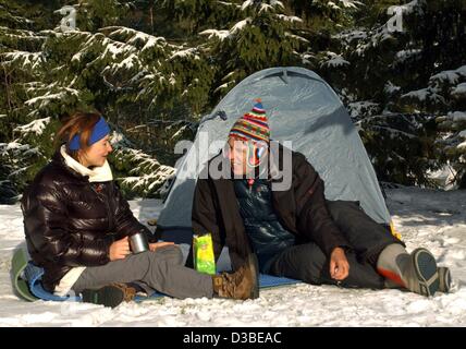 (Dpa) - Due camper godetevi il sole invernale su un campeggio in Dittersdorf (Germania), 1 gennaio 2003. Sebbene temperature di meno 12 gradi Celsius alla fine dell'anno camping appassionati hanno un grande tempo trascorrere il Capodanno nella loro roulotte e tende di montagna. Foto Stock